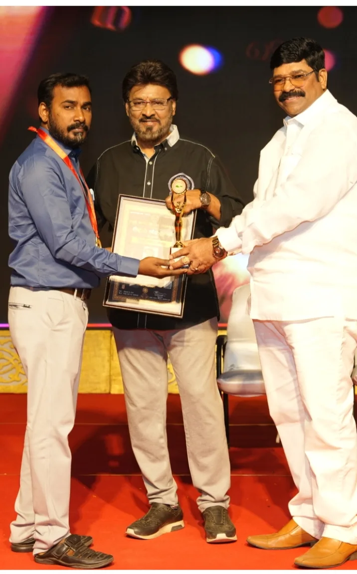 Artist Mylai Kanagaraj receiving an award on stage